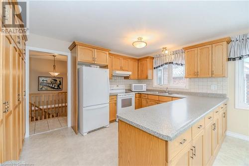 Kitchen featuring sink, backsplash, kitchen peninsula - 64 Cottonwood Crescent, Cambridge, ON - Indoor Photo Showing Kitchen