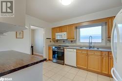 Kitchen featuring wood counters, decorative backsplash, white appliances, sink, and light tile patterned floors - 