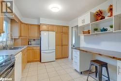 Kitchen with white appliances, a kitchen breakfast bar, sink, light tile patterned flooring, and butcher block counters - 