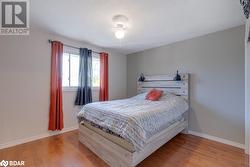 Bedroom with ceiling fan, a textured ceiling, and light hardwood / wood-style flooring - 