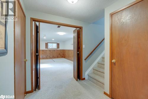 Hall with wood walls, light carpet, and a textured ceiling - 47 Westfield Drive, St. Catharines, ON - Indoor Photo Showing Other Room