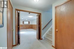 Hall with wood walls, light carpet, and a textured ceiling - 