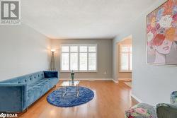 Living room with hardwood / wood-style floors, a textured ceiling, and plenty of natural light - 