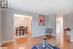 Living area with wood-type flooring and a notable chandelier - 