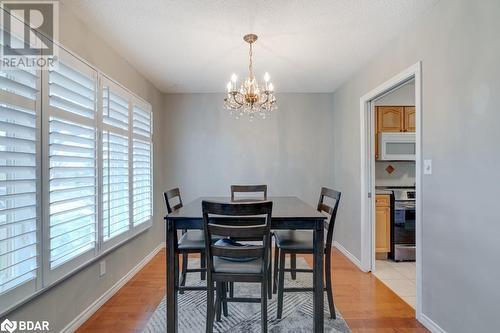 Dining room with a notable chandelier, a healthy amount of sunlight, a textured ceiling, and light hardwood / wood-style flooring - 47 Westfield Drive, St. Catharines, ON - Indoor Photo Showing Dining Room