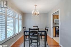 Dining room with a notable chandelier, a healthy amount of sunlight, a textured ceiling, and light hardwood / wood-style flooring - 