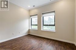 Empty room featuring dark hardwood / wood-style floors and ornamental molding - 