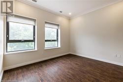 Spare room with dark wood-type flooring and ornamental molding - 