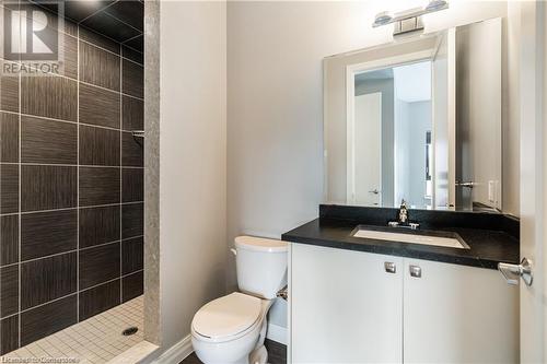 Bathroom featuring a tile shower, vanity, and toilet - 112 King Street E Unit# 305, Hamilton, ON - Indoor Photo Showing Bathroom