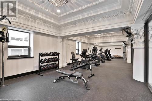 Exercise room featuring a chandelier, ornate columns, crown molding, and a tray ceiling - 112 King Street E Unit# 305, Hamilton, ON - Indoor Photo Showing Gym Room