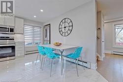 Dining space with light hardwood / wood-style flooring, baseboard heating, and a healthy amount of sunlight - 