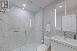 Bathroom with vanity, toilet, and a shower with shower door - 