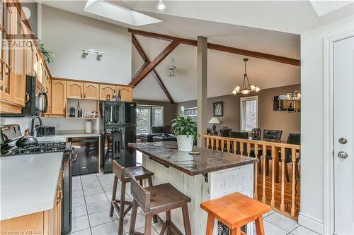 Kitchen with pendant lighting, a center island, black appliances, vaulted ceiling with skylight, and a chandelier - 46 Hodgins Crescent, Woodstock, ON - Indoor