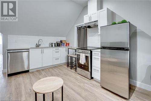 Kitchen with white cabinets, appliances with stainless steel finishes, and decorative backsplash - 102 Wellington Street N Unit# 4, Hamilton, ON - Indoor Photo Showing Kitchen