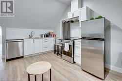 Kitchen with white cabinets, appliances with stainless steel finishes, and decorative backsplash - 