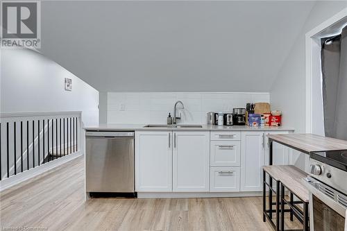 Kitchen with white cabinetry, dishwasher, lofted ceiling, and sink - 102 Wellington Street N Unit# 4, Hamilton, ON - Indoor Photo Showing Kitchen