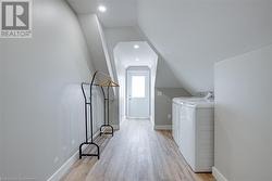 Laundry area with washer and dryer and light wood-type flooring - 