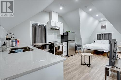 Bedroom with light hardwood / wood-style floors, sink, stainless steel refrigerator, and vaulted ceiling - 102 Wellington Street N Unit# 4, Hamilton, ON - Indoor Photo Showing Kitchen With Double Sink