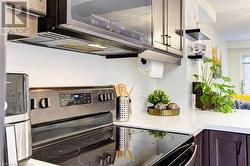 Kitchen with dark brown cabinetry and stainless steel appliances - 