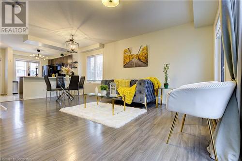 Living room featuring dark hardwood / wood-style flooring, a healthy amount of sunlight, and an inviting chandelier - 350 Dundas Street S Unit# 30, Cambridge, ON - Indoor Photo Showing Living Room