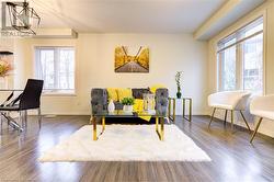 Sitting room with dark hardwood / wood-style floors, a wealth of natural light, and a notable chandelier - 