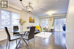 Dining room with a chandelier, a textured ceiling, dark hardwood / wood-style floors, and a healthy amount of sunlight - 