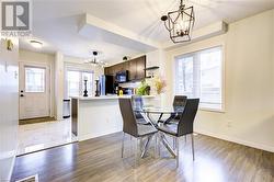 Dining space with wood-type flooring, a healthy amount of sunlight, and a notable chandelier - 