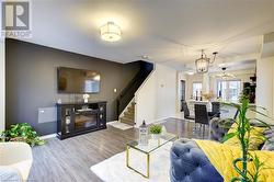 Living room featuring wood-type flooring and a notable chandelier - 