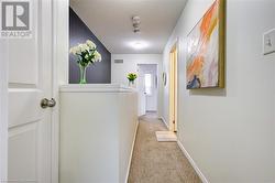 Corridor with a textured ceiling and light colored carpet - 