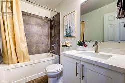 Full bathroom featuring shower / bath combination with curtain, toilet, wood-type flooring, and vanity - 