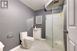 Bathroom featuring tile patterned flooring, vanity, toilet, and walk in shower - 