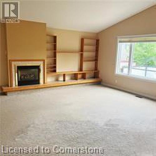 Unfurnished living room with carpet flooring and vaulted ceiling - 17 Hawkswood Drive, Kitchener, ON - Indoor With Fireplace