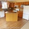 Kitchen with a center island, hanging light fixtures, white appliances, and light hardwood / wood-style flooring - 17 Hawkswood Drive, Kitchener, ON  - Indoor Photo Showing Kitchen 