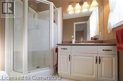 Bathroom with vanity and a shower with shower door - 