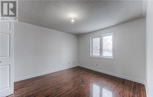 Spare room featuring dark hardwood / wood-style flooring and a textured ceiling - 21 Woodborough Place, Cambridge, ON - Indoor Photo Showing Other Room