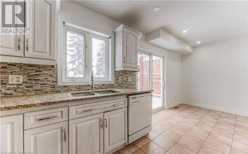 Kitchen with white dishwasher, white cabinets, sink, light stone countertops, and tasteful backsplash - 21 Woodborough Place, Cambridge, ON - Indoor Photo Showing Kitchen