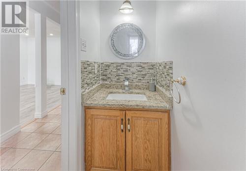 Bathroom featuring tile patterned flooring, vanity, and backsplash - 21 Woodborough Place, Cambridge, ON - Indoor Photo Showing Bathroom