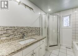 Bathroom with tile patterned flooring, vanity, and an enclosed shower - 