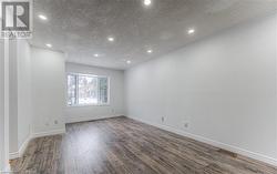 Empty room featuring dark hardwood / wood-style floors and a textured ceiling - 