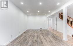 Basement with light hardwood / wood-style floors and a textured ceiling - 