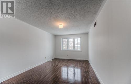 Unfurnished room with dark wood-type flooring and a textured ceiling - 21 Woodborough Place, Cambridge, ON - Indoor Photo Showing Other Room