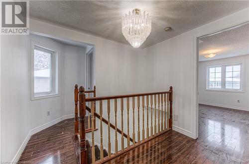 Hallway with dark hardwood / wood-style flooring, a chandelier, and a textured ceiling - 21 Woodborough Place, Cambridge, ON - Indoor Photo Showing Other Room