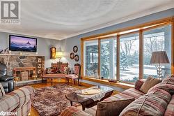 Living room with a fireplace, wood-type flooring, and ornamental molding - 