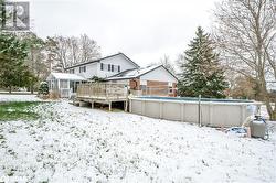 Snow covered house featuring a sunroom and a swimming pool side deck - 