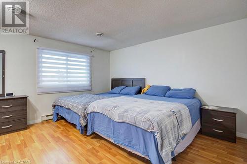 Bedroom featuring a textured ceiling, baseboard heating, and light hardwood / wood-style flooring - 255 Lansdowne Avenue Unit# 3, Woodstock, ON - Indoor Photo Showing Bedroom