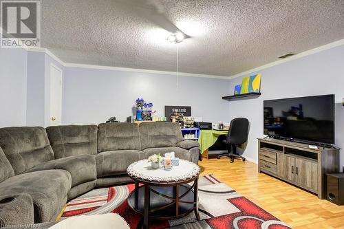 Living room with ornamental molding, a textured ceiling, and hardwood / wood-style flooring - 255 Lansdowne Avenue Unit# 3, Woodstock, ON - Indoor Photo Showing Living Room