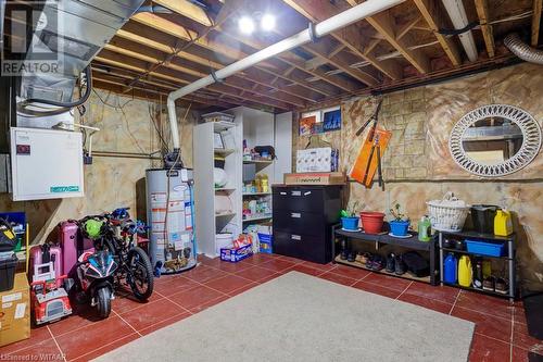 Basement with dark tile patterned floors and water heater - 255 Lansdowne Avenue Unit# 3, Woodstock, ON - Indoor Photo Showing Basement