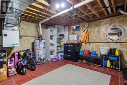 Basement with dark tile patterned floors and water heater - 