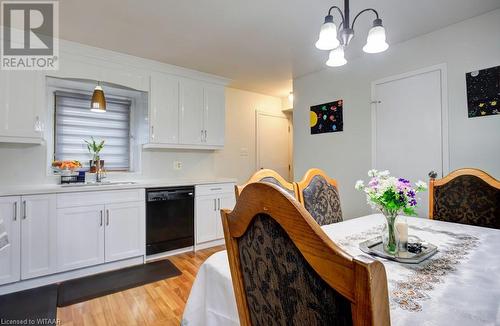 Kitchen with sink, black dishwasher, decorative light fixtures, light hardwood / wood-style floors, and white cabinetry - 255 Lansdowne Avenue Unit# 3, Woodstock, ON - Indoor Photo Showing Dining Room