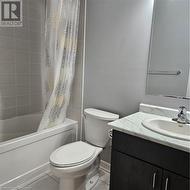 Full bathroom with tile patterned floors, shower / bath combo with shower curtain, vanity, and toilet - 